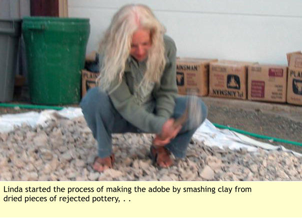 Linda started the process of making the adobe by smashing clay from dried pieces of rejected pottery, . .